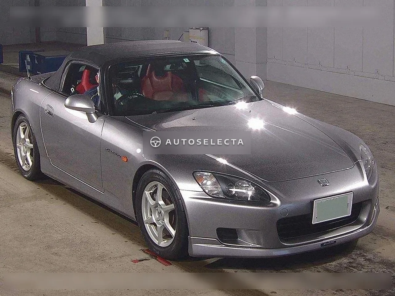 Grey 2001 Honda S2000 AP1 front three quarter view with black soft top, silver alloy wheels and front lip spoiler
